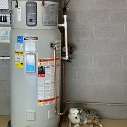 Tankless Pros Water Heaters - 65-Gallon Electric Heat Pump with our sweet four legged customer, Bella, posed right next to it.