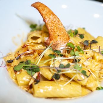Bistro 72 - a plate of pasta with a piece of bread and sprouts - American Near Me - Riverhead, New York