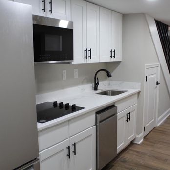 H And H Construction - a kitchen with white cabinets and stainless steel appliances - Flooring Near Me - Madras, District of Columbia