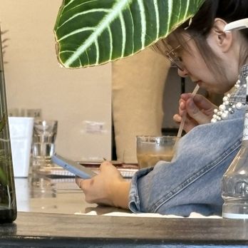 Blue Kale Cafe & Lounge - Employee on phone chilling out. - Cafes Near Me - Skokie, Illinois