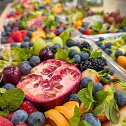 Orders UP - Colorful fruit trays featuring pomegranate, grapes, kiwi, berries, and mint.Colorful fruit trays featuring pomegranate, grapes, kiwi, berrie