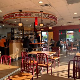 Inside of Popeyes. A picture which shows guests waiting for food. A smokey room and dirty floors and tables.