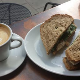 Large latte with chicken, brie and cranberry sandwich pre-falling to pieces. Large latte with chicken, brie and cranberry sandwich pre-falling to pieces.