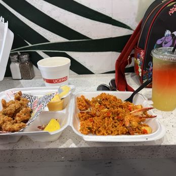 The Licking - Conch fritters with dipping sauce and a lemon wedge with seafood rice and mystery drink - Soul Food Near Me - Miami, Florida