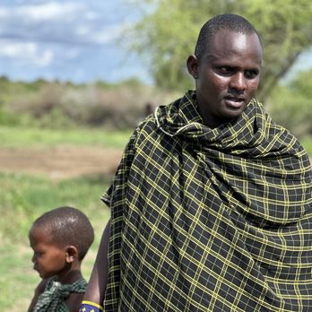 Bush Signature - Maasai man and one of his ten children - Tours Near Me Bush Signature - Maasai man and one of his ten children - Tours Near Me