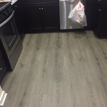 Freddy's Flooring - a kitchen with dark cabinets and a stainless steel dishwasher - Flooring Near Me