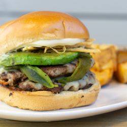 Taste Community Restaurant - Poblano Smash Burger
Two all-beef patties smashed with Monterey Jack cheese, roasted poblano chilis, avocado, fried corn chips, and aioli.
