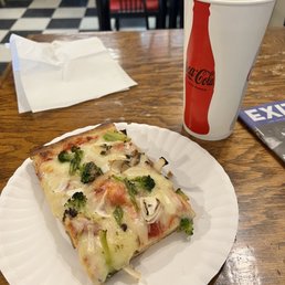 a slice of pizza on a paper plate