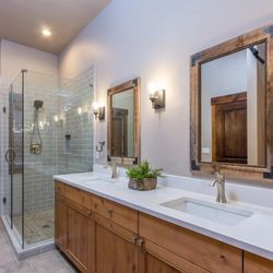 ManUp Construction - Expertly crafted bathroom remodel with precise wood detailing, flawless dual vanity, and a sleek glass shower. Premium workmanship in Bend.