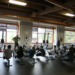 Pocock Rowing Center - Coach working with students on the rowing machines.