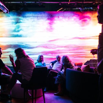 Wiggle Room Austin - a group of people sitting around a table - DJs Near Me - Austin, Texas
