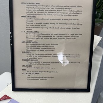 Refresh Nail Care - Store policy - A framed policy sign for Refresh Nail Care is positioned on a white surface, with the frame being black. The sign contains detailed text about the salon's policies, including medical conditions, skin conditions, nail enhancements, gift certificates, children, property damage, rights, pets, and payment methods. The background of the sign is white with black text, and the frame appears to be made of a simple black material. The surface underneath the frame is white and textured, and part of a magazine or brochure is visible at the bottom left corner of the image. - Nail Salons Near Me - Pacifica, California