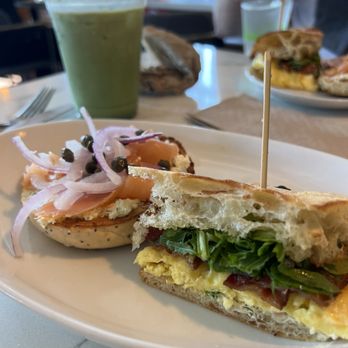 Station - Half of the smoked salmon bagel sandwich and half of the breakfast sandwich on ciabatta with bacon, with matcha iced latte. - Coffee & Tea Near Me - Granville, Ohio Station - Half of the smoked salmon bagel sandwich and half of the breakfast sandwich on ciabatta with bacon, with matcha iced latte. - Coffee & Tea Near Me - Granville, Ohio