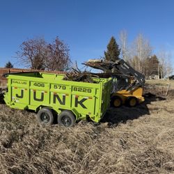 Junk in the Trunk Bozeman Junk Removal - "Skid steer loading yard debris and brush into our trailer during a property cleanout."