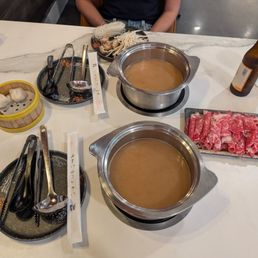 Two broths and a selection of meats Two broths and a selection of meats