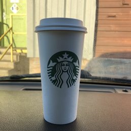 a starbucks cup on the dashboard of a car a starbucks cup on the dashboard of a car