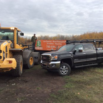 The Junk Guys - a black truck and a yellow tractor - Junk Removal & Hauling Near Me - Saint Albert, Alberta