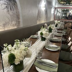 Dinner party at Ameni restaurant  with white and greens down the middle of the table