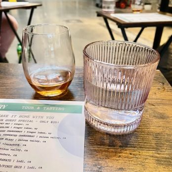 Brooklyn Winery - Two glasses, one with rosé wine and the other with water, are placed on a wooden table at a winery or restaurant setting. - Venues & Event Spaces Near Me - Brooklyn, New York