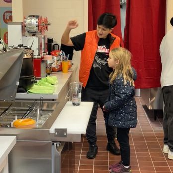 Kung Fu Tea - My oldest getting a demonstration by the owner of how the machine seals lids on the drinks. - Juice Bars & Smoothies Near Me - West Jordan, Utah