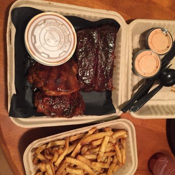 Sweetwood BBQ - The two meat two-side meal. With chicken and ribs fries and barbecue beans to go notice no napkins - Barbeque Near Me - Wenatchee, Washington