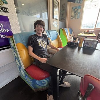 Obi's Fillin Station - my boyfriend sitting on car seats that are used for diner chairs - American Near Me - Saint Augustine, Florida