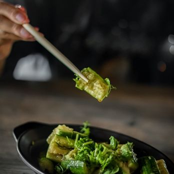 Kungfu Ramen - a person holding chopsticks over a plate of broccoli - Noodles Near Me - Tempe, Arizona
