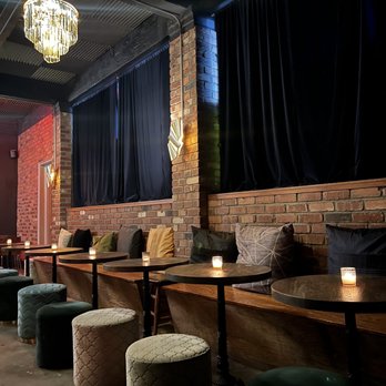 The Alley - a row of tables and stools with candles on them - Cocktail Bars Near Me - Seattle, Washington The Alley - a row of tables and stools with candles on them - Cocktail Bars Near Me - Seattle, Washington