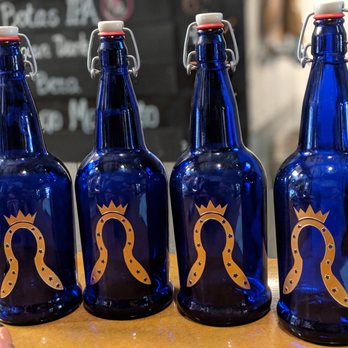 Guadalupe Brewery - a row of blue glass beer bottles with gold designs - Breweries Near Me - Carlsbad, California Guadalupe Brewery - a row of blue glass beer bottles with gold designs - Breweries Near Me - Carlsbad, California