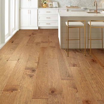 Mary’s Carpet & Flooring - a kitchen with white cabinets and wood floors - Flooring Near Me Mary’s Carpet & Flooring - a kitchen with white cabinets and wood floors - Flooring Near Me