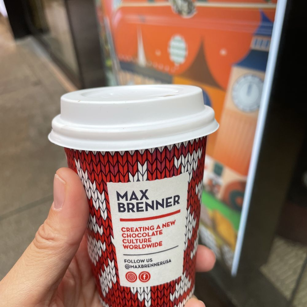 Max Brenner Times square - Chocolate Shop - a hand holding a cup of coffee - Chocolatiers & Shops Near Me - New York, New York