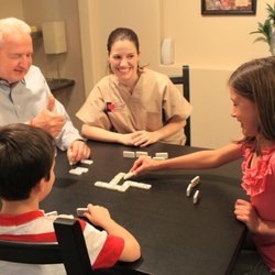 Caring Senior Service caregiver playing games with a client and his family