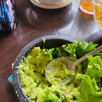 El Fenix - a bowl of guacamole with a spoon in it - Mexican Near Me - Irving, Texas