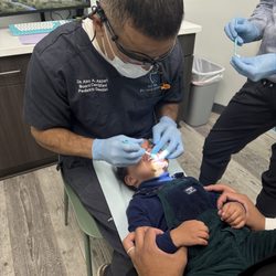 All Star Pediatric Dentistry - Dr. Alex Akbari cleaning toddler's teeth.
