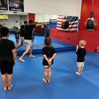 Glory Martial Arts - Coach Rich teaching the kids class the proper way to use a right cross in kickboxing class. - Kickboxing Near Me Glory Martial Arts - Coach Rich teaching the kids class the proper way to use a right cross in kickboxing class. - Kickboxing Near Me