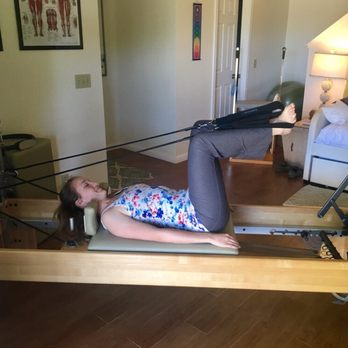 Somatic Pilates - "Frog" exercise with feet in straps on the Reformer - Pilates Near Me