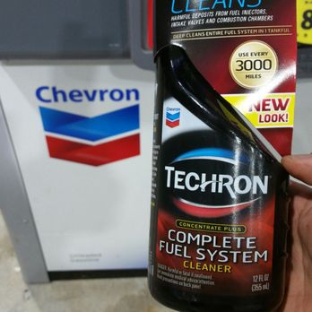 Chevron - a hand holding a bottle of techron complete fuel system - Gas Stations Near Me - Duluth, Georgia