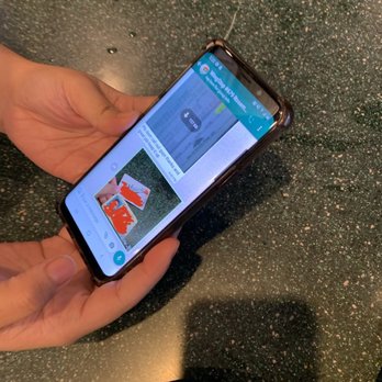 Wingstop - a person holding a cell phone in their hand - Chicken Wings Near Me - Rosemead, California