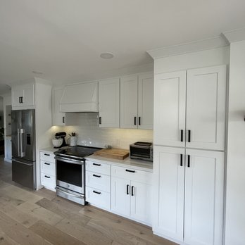 DK Production - a kitchen with white cabinets and a black stove - General Contractors Near Me - Marysville, Washington DK Production - a kitchen with white cabinets and a black stove - General Contractors Near Me - Marysville, Washington