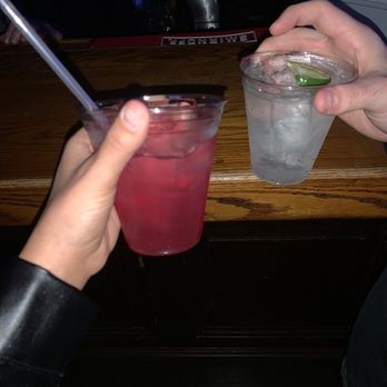 The Inn - two people holding drinks at a bar - American Near Me - Long Beach, New York The Inn - two people holding drinks at a bar - American Near Me - Long Beach, New York