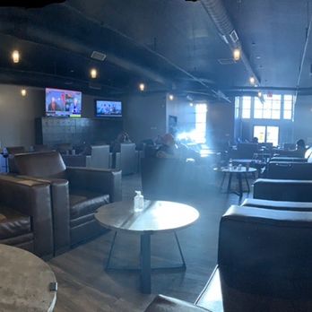 Cigar Sessions - A large lounge with leather seating, several TVs, and a bar area with patrons, illuminated by natural and artificial light. - Lounges Near Me - Middletown, Delaware