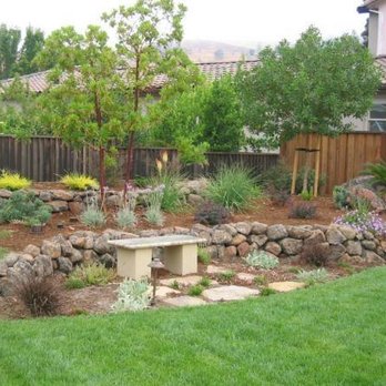 Living Outdoors Landscapes - a stone bench in a garden - Landscaping Near Me Living Outdoors Landscapes - a stone bench in a garden - Landscaping Near Me
