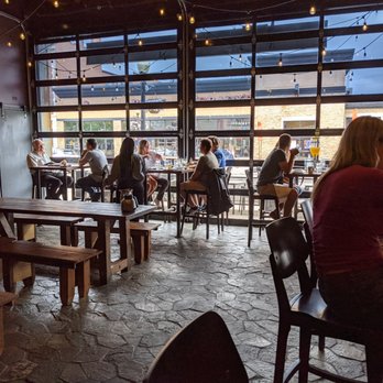 Pop's For Italian - High tops and picnic tables near the eye-catching garage doors. - Italian Near Me - Ferndale, Michigan
