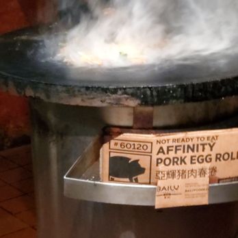 Mongolian BBQ - a person cooking food in a wok - Mongolian Near Me - Stillwater, Minnesota