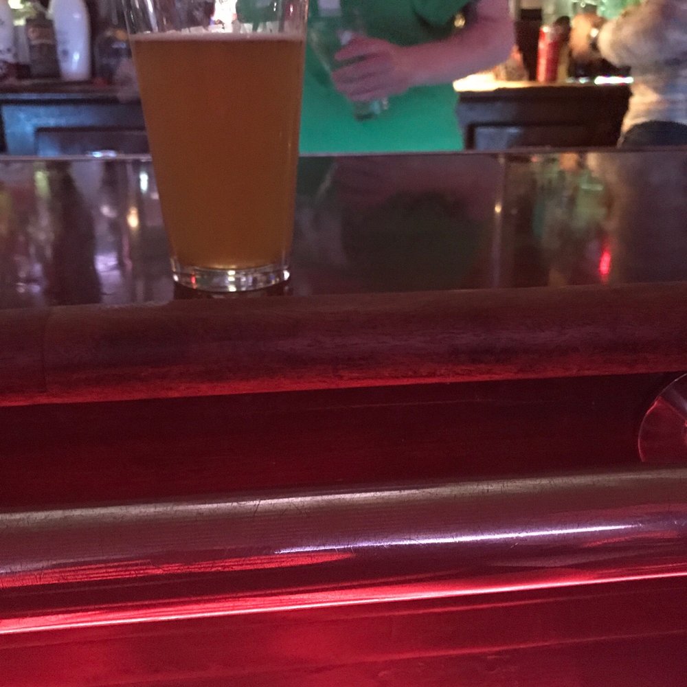 a glass of beer on a bar counter a glass of beer on a bar counter