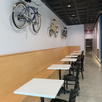 Uptown Dairy - a row of tables and a row of bikes hanging on the wall - Ice Cream & Frozen Yogurt Near Me - Ankeny, Iowa Uptown Dairy - a row of tables and a row of bikes hanging on the wall - Ice Cream & Frozen Yogurt Near Me - Ankeny, Iowa