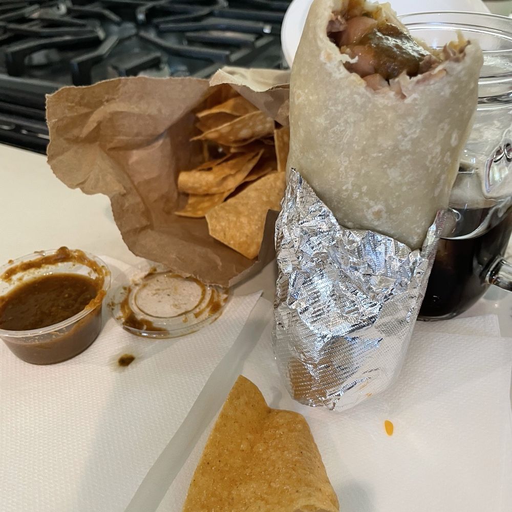 Baby Chile verde burrito minus a bite, chips and hot sauc