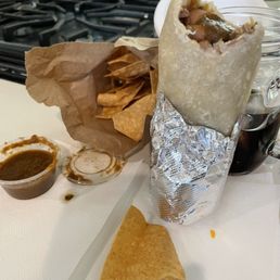 Baby Chile verde burrito minus a bite, chips and hot sauc Baby Chile verde burrito minus a bite, chips and hot sauc