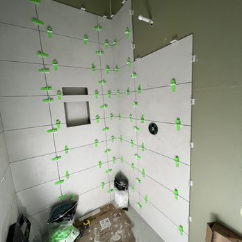 Ek Construction - a bathroom with green tape on the walls - Siding Near Me