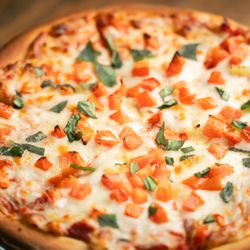 St. Nick's Patio & Grille - Christmas Pie with homemade pizza sauce, mozzarella, fresh tomatoes, and fresh cut basil.